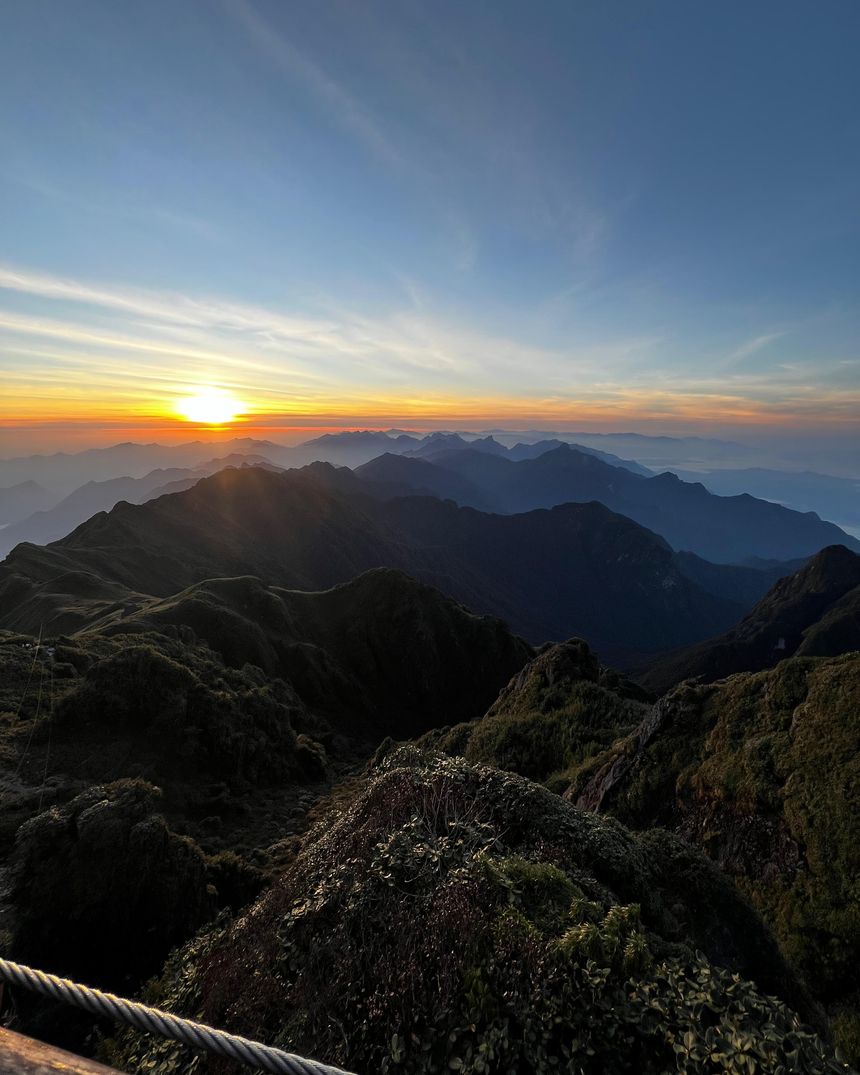 Sunrise above a sea of mountain ridges, seen from a high summit